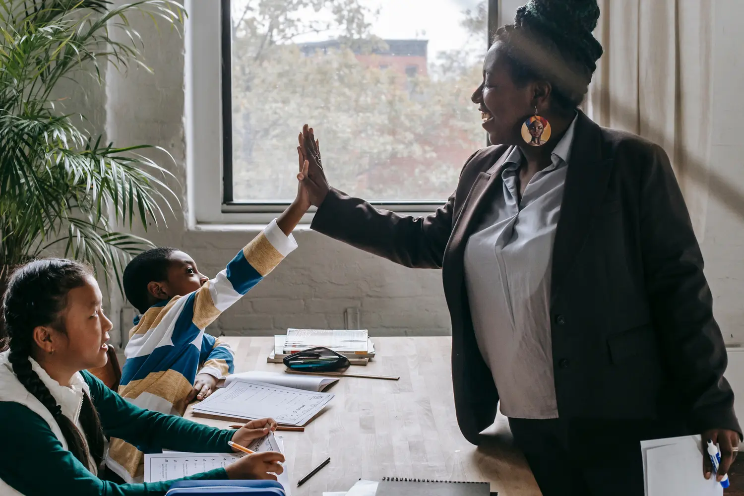 Teacher celebrating student participation with a high five